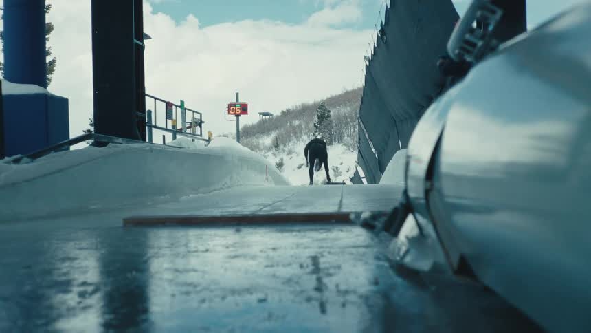 A person pushing a platform on top of a skeleton sports ice rink