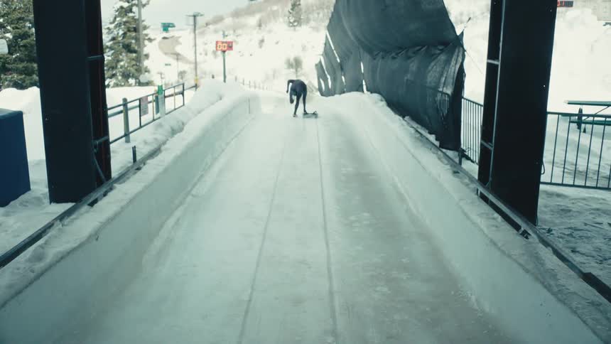 Person running at high speed on an ice rink practicing skeleton