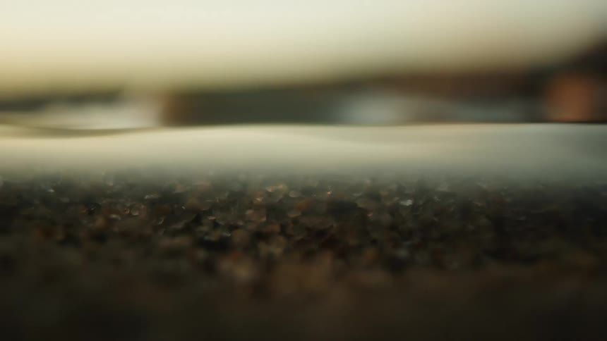 A liquid surface with a layer of sediment visible beneath