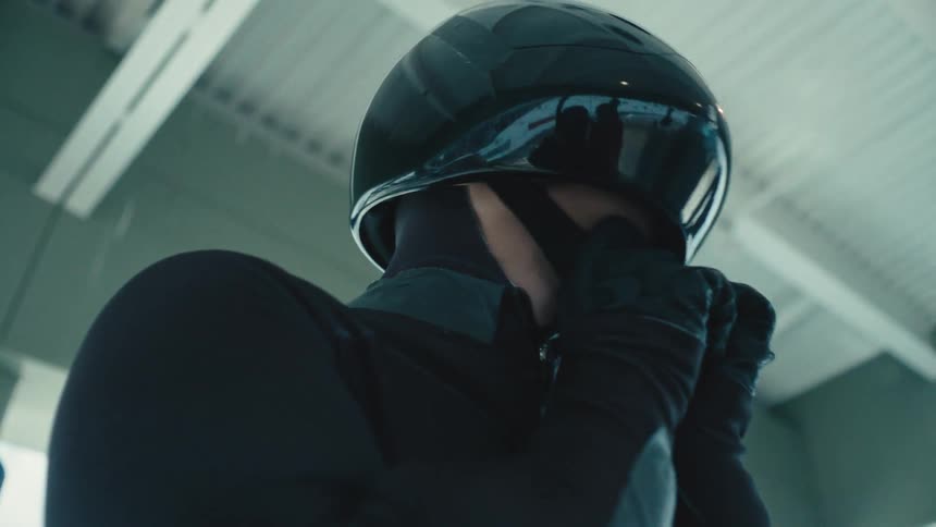 Man putting on a black protective helmet