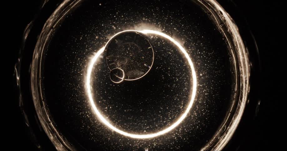 Some abstract and bright circular shapes rotating at the same time and there are two bubbles in the center