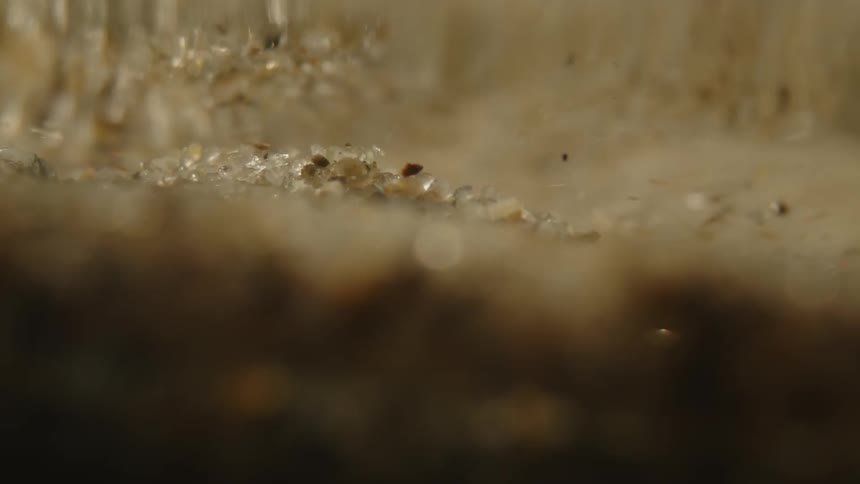 Some water falling on a ground with many pebbles and the water is getting cloudy