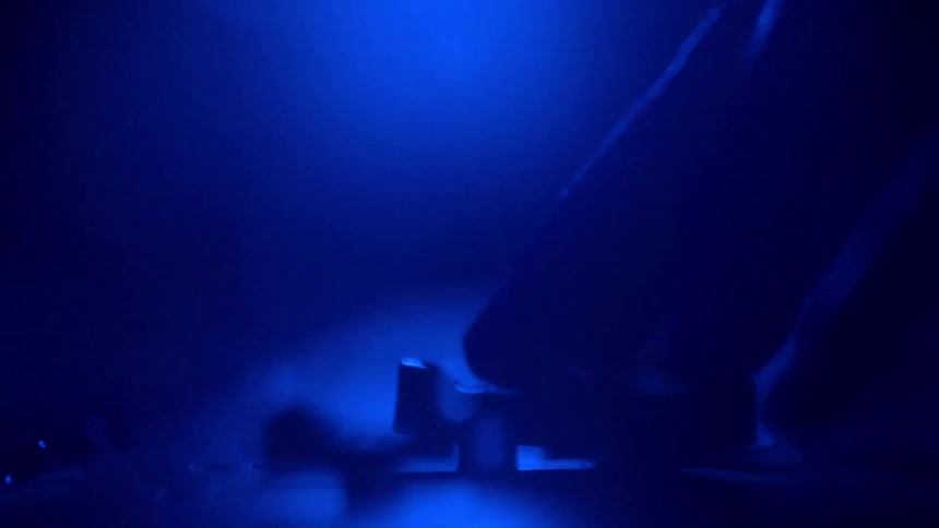A persons finger pushing a button down in a room that is all blue