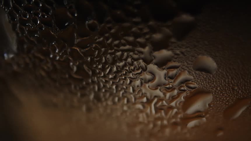 Water droplets on a textured brown glass surface