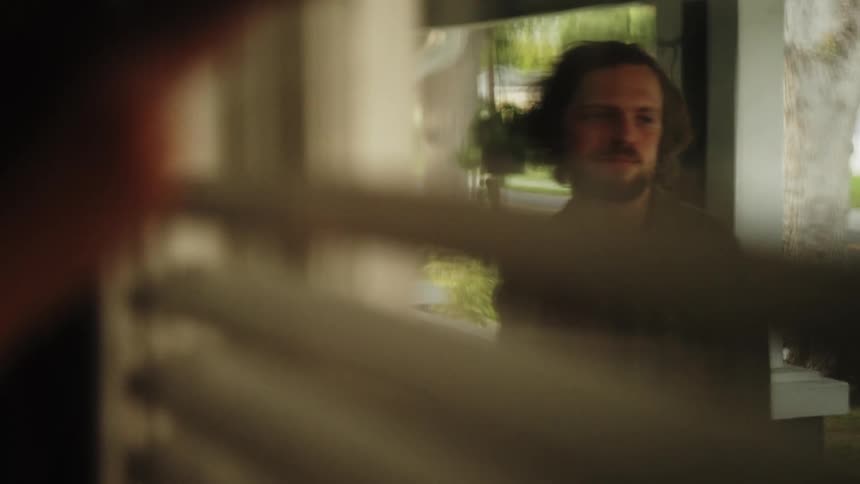 View through a window curtain of a man outside the house