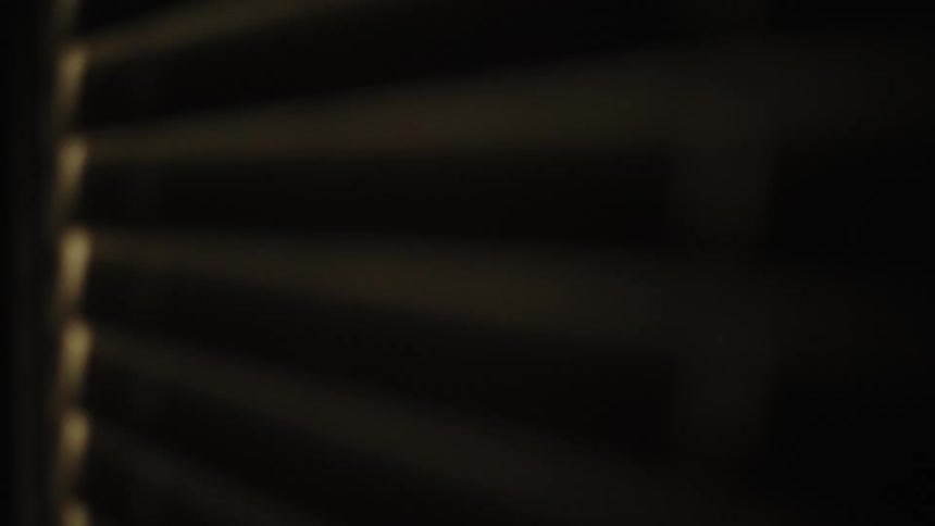 Hand opening window curtain and seeing a man outside