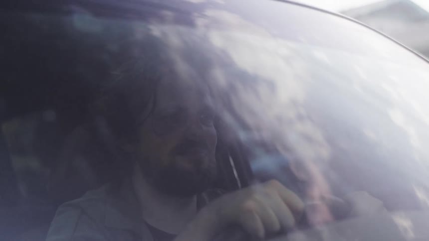 Man driving a car during the day
