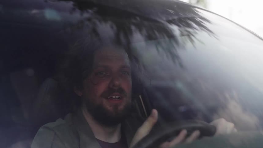 A footage of a man angry and crying while driving a car