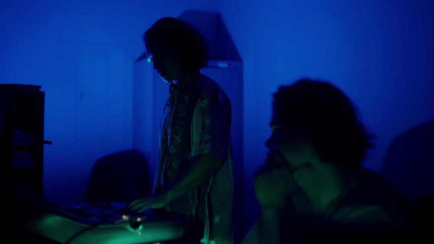 Male worker in a sound studio watches while his coworker provides direction