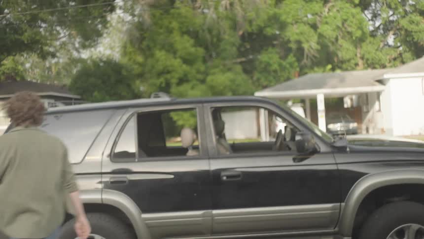 A man is peaking through a window seemingly looking for someone he shows his frustration and leaves getting in his car