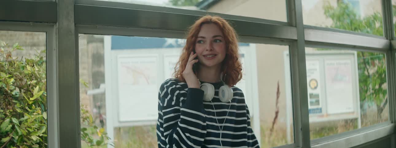 A woman waits at a bus stop