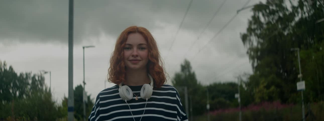 Young woman walking in an outdoor area with happy facial expression