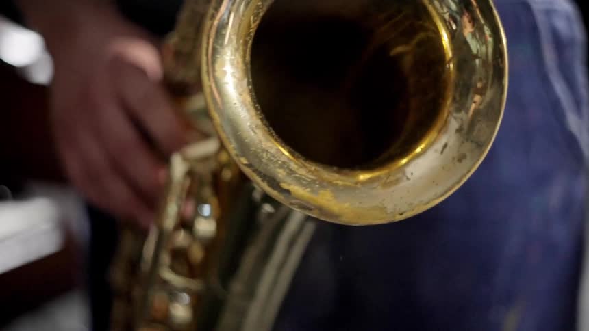 Close up of a person holding and playing a saxophone