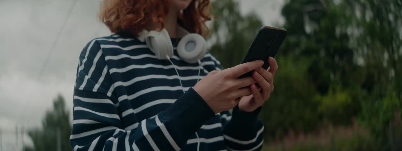 Outside during spring a female is texting on her phone