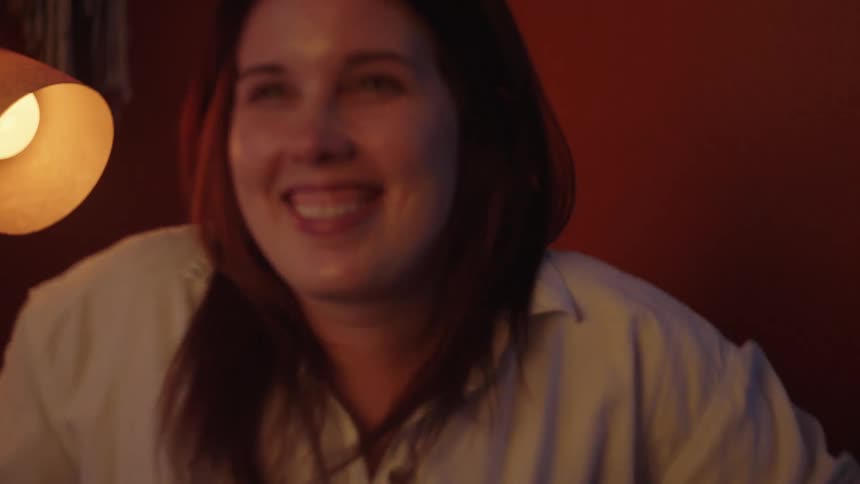 A woman smiles and stands
