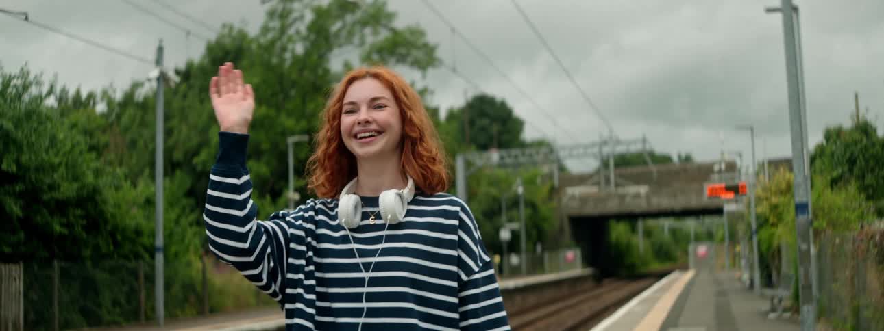 Young woman waving hand happily