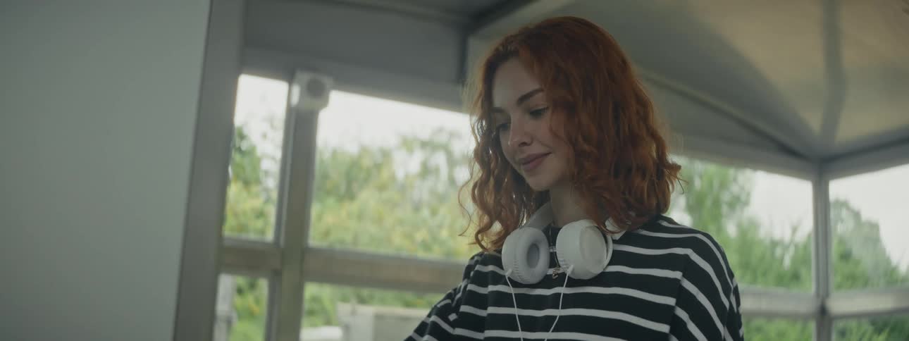 Redhaired woman with curly hair in an indoor space