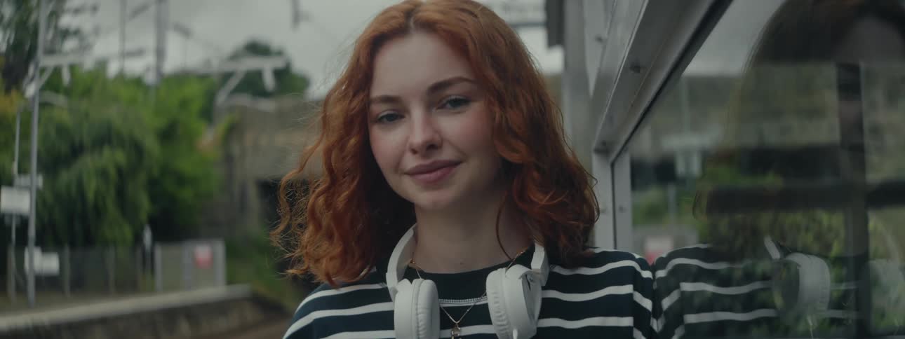 A clip of a female standing outdoor and smiling