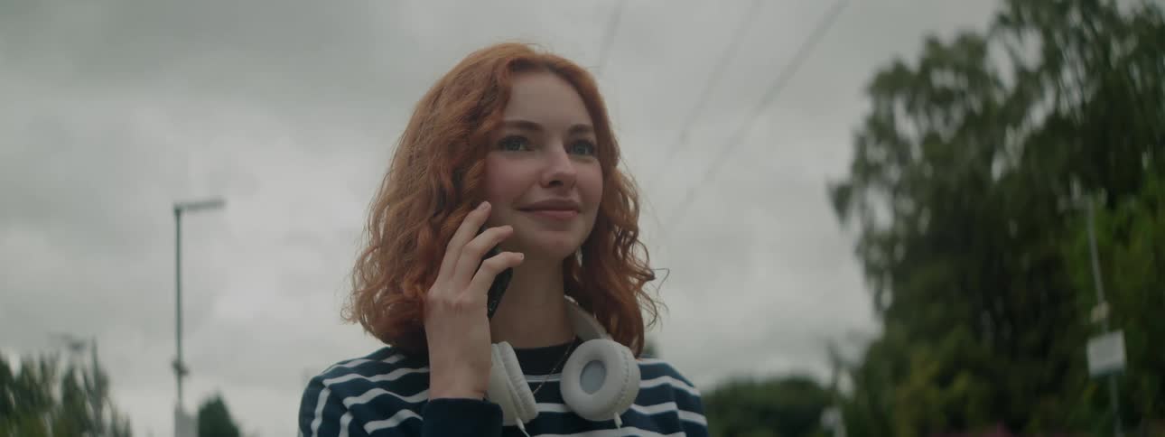 A woman smiles while on the phone