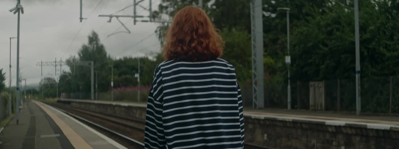 Back view of a woman walking in an outdoor subway station