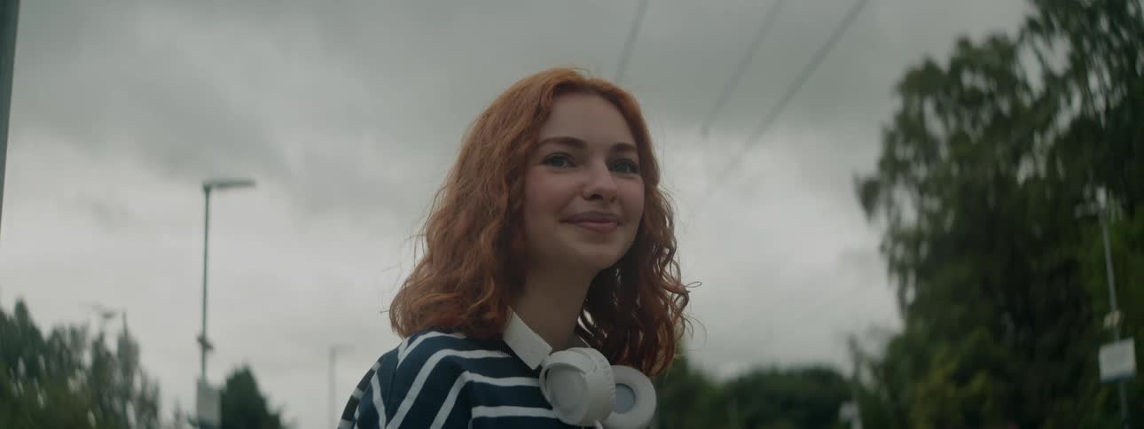 Teenager smiling while walking through a suburban city in spring