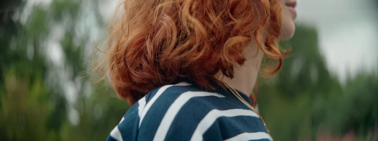 A close up clip of a lady standing beside the rail track