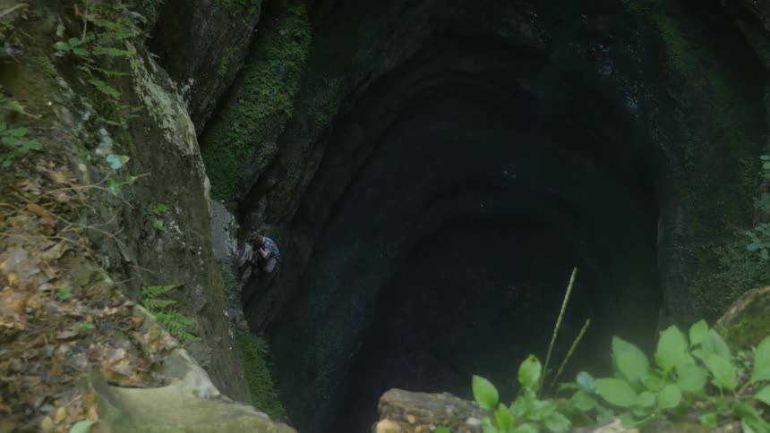 A man climbs in a deep cavern
