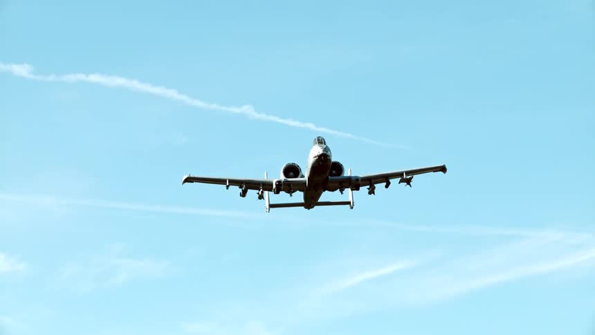 An a10 thunderbolt ii attack aircraft flies overhead against a blue sky