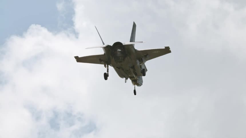 A jet flying slowly in a blue sky with white clouds