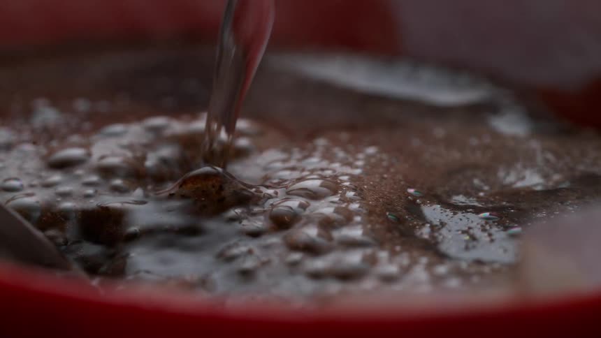 Boiling water is being poured into a red cup