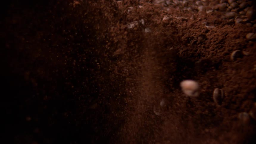 Coffee beans and grounds are mixed together rapidly creating a swirling vortex