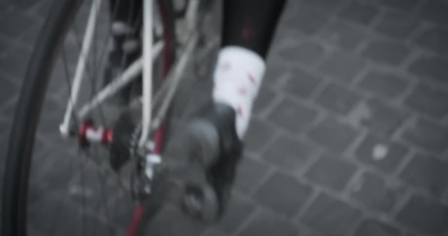 A person is pushing off of a bicycle and starting to ride it