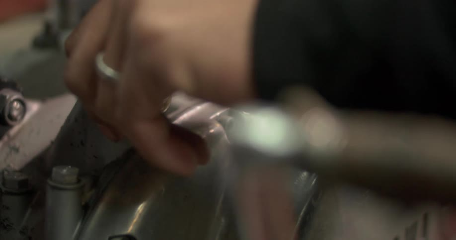 A close up clip of a person repairing a bike engine