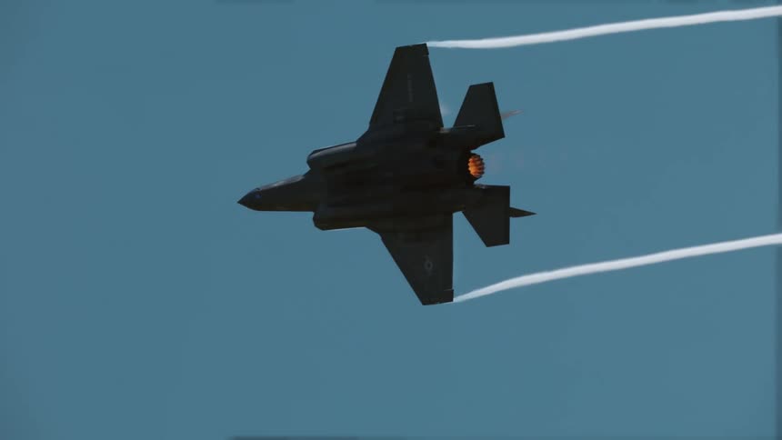 Military fighter jet in full flight releasing condensation trails