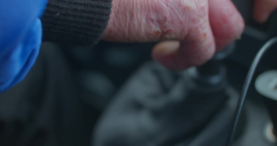 A human hand moving the lever of a car transmission