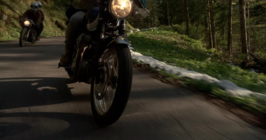 People are riding their motorcycles on a path in the woods
