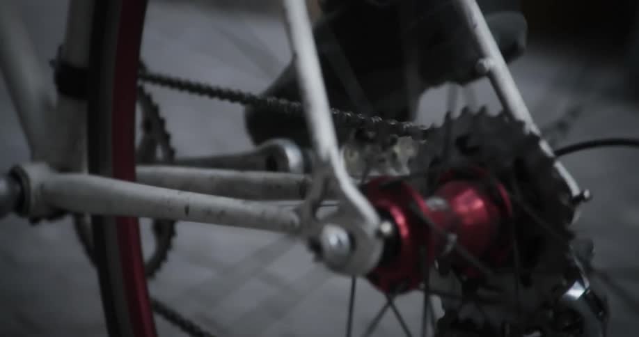 A cyclists foot steadily propels the bike forward with each pedal stroke in the city street