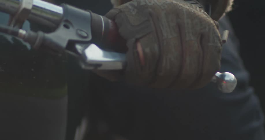 Hand with gloves driving a motorcycle