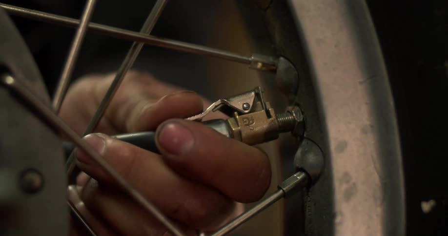 Hand placing an air pressure hose on the wheel