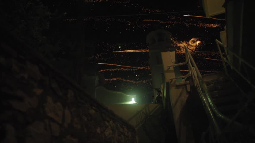 Dark view of fireworks shooting all over a night sky