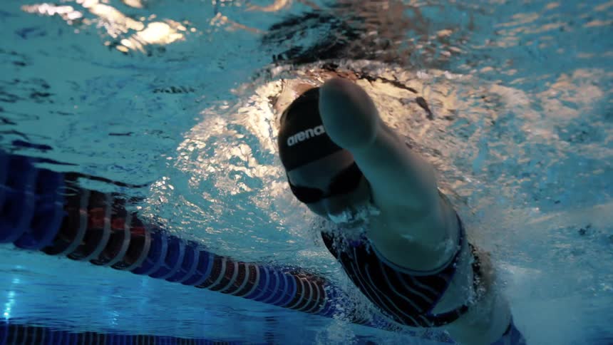 Female swimmer with a missing forelimb swims through a swimming pool