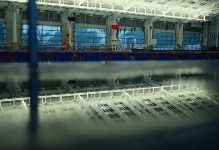 Lights turn on in a large room with a pool