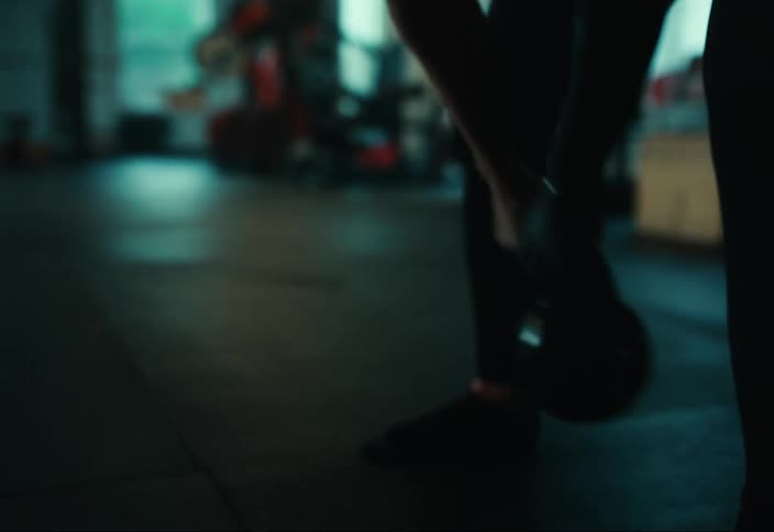 Woman holding a weight and exercising in the gym