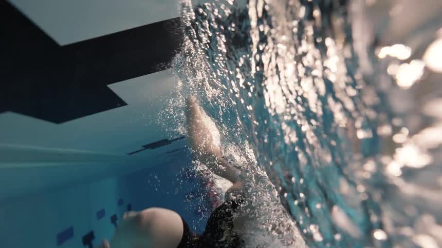 Swimmer turns while doing laps in a large swimming pool