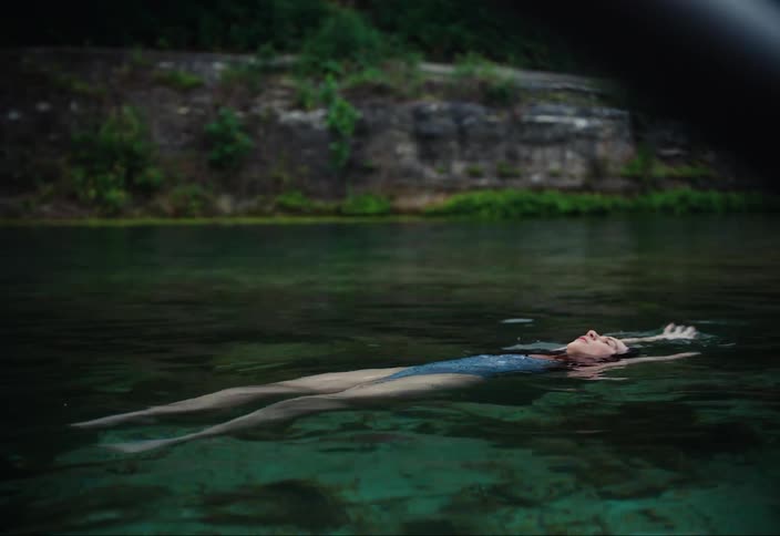 Woman swimming in a lake on her back