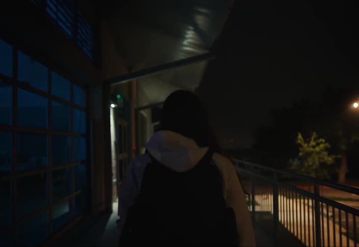 A person walks past a building and then enters