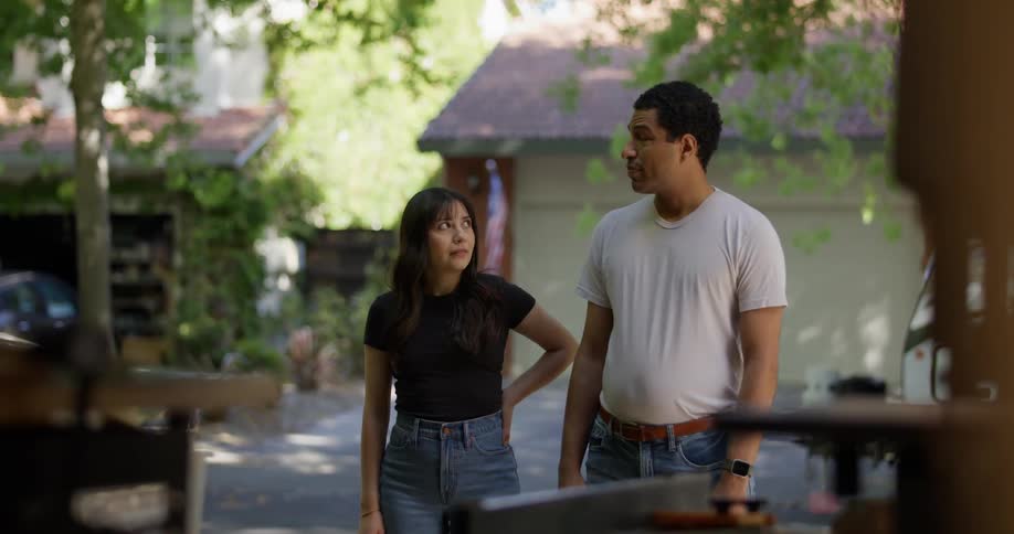 A couple stand side by side in a driveway looking at the interior of a garage