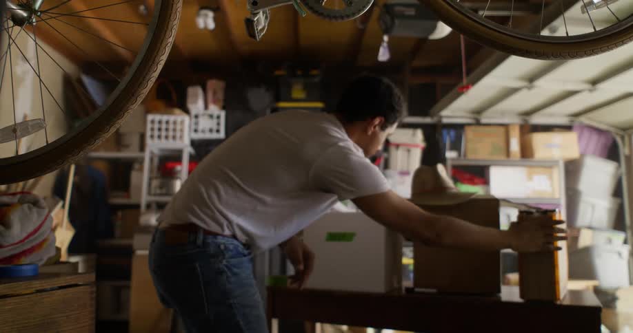 Man taking out a plastic box and putting a cardboard box in the same place