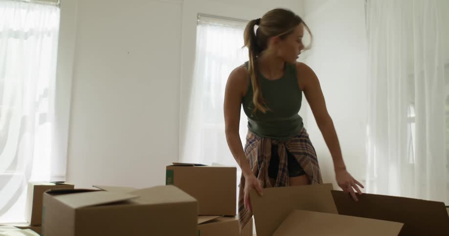 A woman looks through boxes in the room