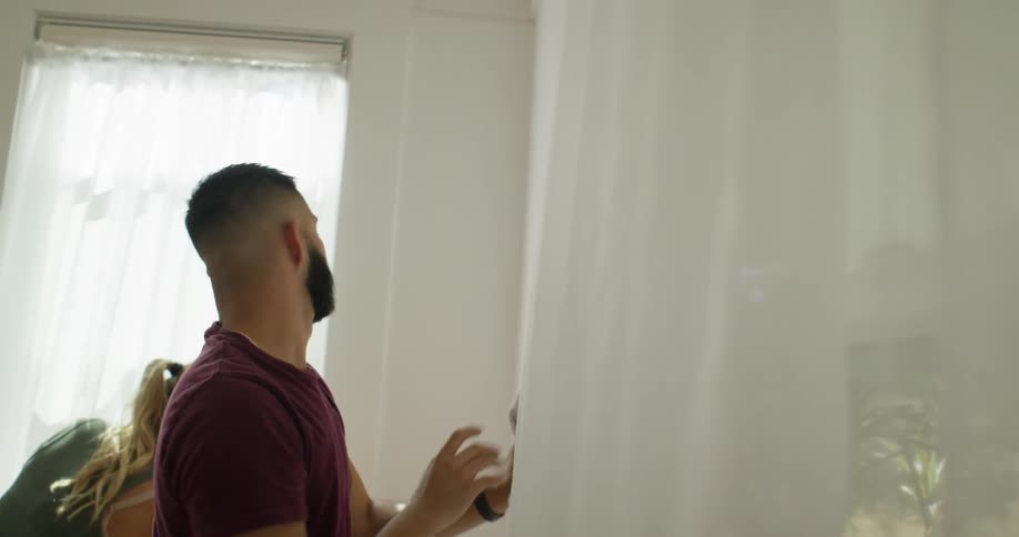 A man and woman are using rags to clean the walls